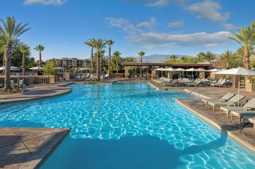 a large swimming pool with chairs and palm trees at The Westin Desert Willow Villas, Palm Desert in Palm Desert