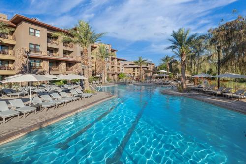 a swimming pool at a resort with chairs and umbrellas at The Westin Desert Willow Villas, Palm Desert in Palm Desert