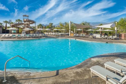 a swimming pool at a resort with chairs and umbrellas at The Westin Desert Willow Villas, Palm Desert in Palm Desert