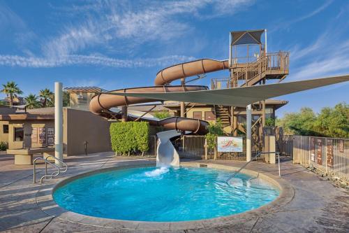 a pool with a water slide in front of a house at The Westin Desert Willow Villas, Palm Desert in Palm Desert