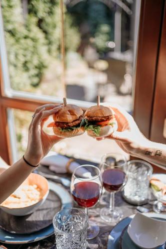 a person holding two sandwiches on a table at Boutique penzion Rech in Blansko