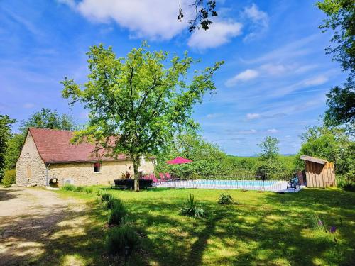 a barn with a tree and a fence at Gîte de la Peyre et du Causse in Florimont-Gaumiers