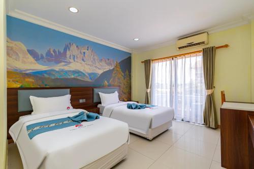 a bedroom with two beds and a painting on the wall at Lisha Roungnakhone Hotel in Vang Vieng
