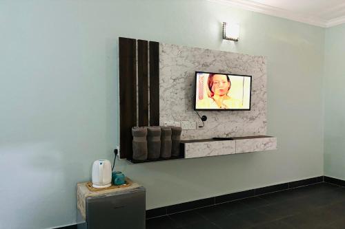 a bathroom with a tv on a wall with at Corrie Chalet Pantai Cenang Langkawi in Pantai Cenang