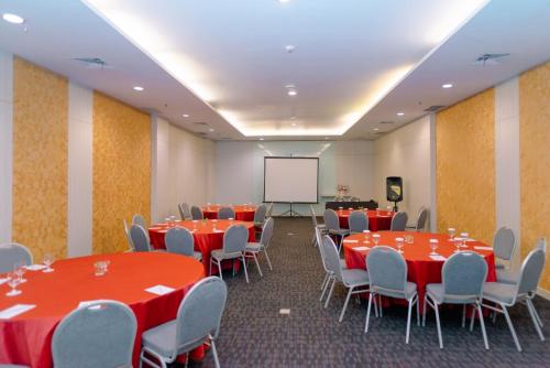 a conference room with tables and chairs and a whiteboard at Sahid Bandara Soekarno Hatta in Tangerang