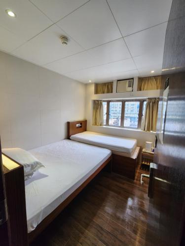 Voodi või voodid majutusasutuse 香港金門賓館 KamMun Guest House toas