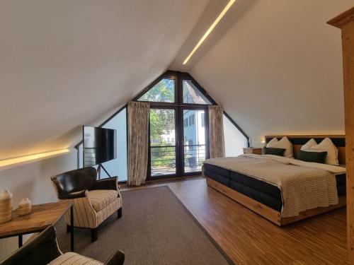 ein Schlafzimmer mit einem großen Bett und einem großen Fenster in der Unterkunft Weiherhof Cottage in Radolfzell am Bodensee