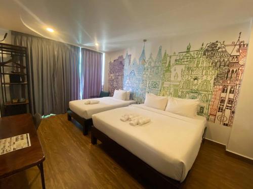 a hotel room with two beds and a mural on the wall at Times Hotel at Bassac Lane in Phnom Penh