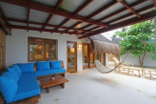 a living room with a blue couch and a hammock at Yapak Beach Villas in San Isidro