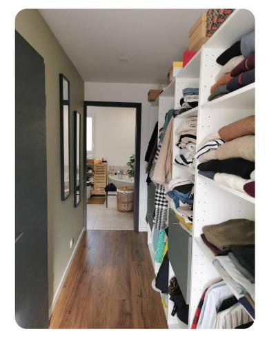 un couloir avec des étagères blanches remplies de vêtements dans l'établissement Maison entre lac et montagne, à Charvonnex