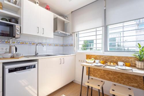 a kitchen with white cabinets and a counter at Sunstay Center Flat I Arroyo De La Miel in Benalmádena
