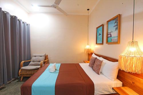 a hotel room with a bed and a chair at Yapak Beach Villas in San Isidro