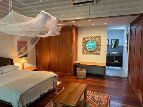a bedroom with a bed and a table and a desk at Casa Luminosa jungle villa in Cocles