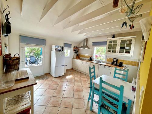 - une cuisine avec des chaises bleues et un réfrigérateur blanc dans l'établissement 480-Villa des dunes de St Tugen, à Esquibien
