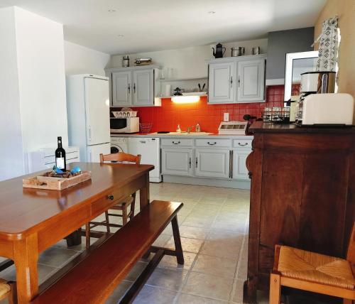 a kitchen with white cabinets and a wooden table at Gîte de la Peyre et du Causse in Florimont-Gaumiers