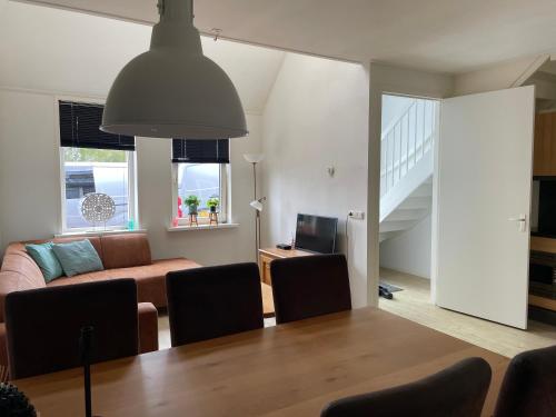 a living room with a table and a couch at Nieuw gebouwd appartement op paarden bedrijf in Buitenpost