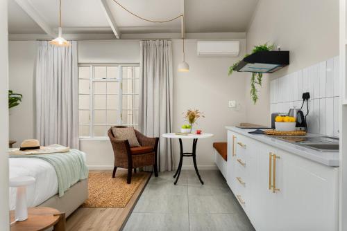 a kitchen and a bedroom with a bed and a table at Neighbourgood Franschhoek in Franschhoek