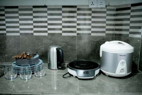 a kitchen counter with a toaster and plates of food at Greenery Garden in Idamegama