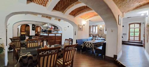 a restaurant with arches and tables and chairs at Gościniec & SPA Darłowo in Darłowo