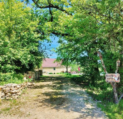 a dirt road with trees and a sign on it at Gîte de la Peyre et du Causse in Florimont-Gaumiers