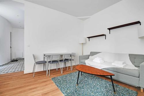 un salon avec un canapé et une table dans l'établissement Comfortable apt - 1BD - 4P - Montmartre, à Paris