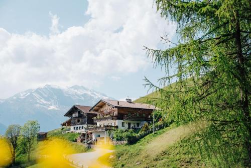 a house on a hill with a mountain in the background at Ferienwohnungen Wiesbauer in Schenna