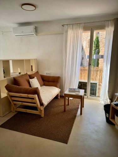 a living room with a couch and a large window at Casa Forta, charm between vines in Capmany