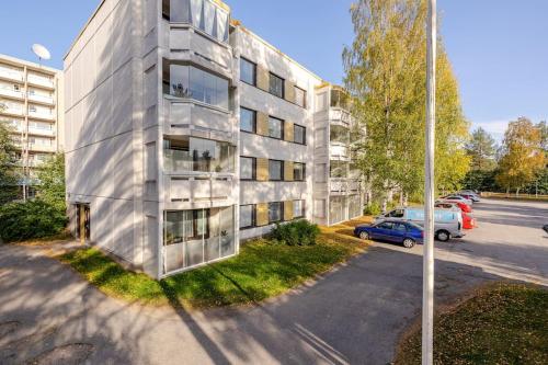 an apartment building with cars parked in a parking lot at Uudistettu studio kahdelle omalla parkkipaikalla in Rovaniemi