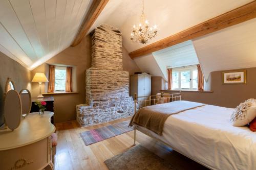 Butterfly Cottage في Wheddon Cross: غرفة نوم بسرير وركن حجري