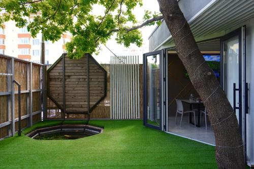 an outdoor patio with green grass and a tree at Гранд Алексік in Truskavets