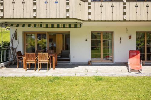 a house with a table and chairs on a patio at Exklusives Chalet mit Panoramablick auf die Eiger Nordwand in Grindelwald