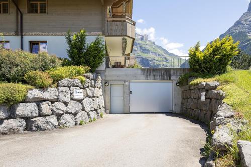 a building with a garage and a stone wall at Exklusives Chalet mit Panoramablick auf die Eiger Nordwand in Grindelwald
