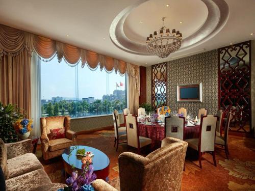 a dining room with a table and chairs and a chandelier at New Century Hotel Putuo Zhoushan in Zhoushan