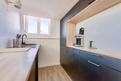 une cuisine avec un évier et un plan de travail dans l'établissement Studio avec mezzanine pour 2 personnes, à Lille