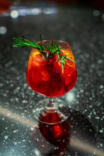 a red drink in a glass on a table at AUHotel -Zayed International Airport-Located in Transit Area -Onwards Boarding Pass Required in Abu Dhabi