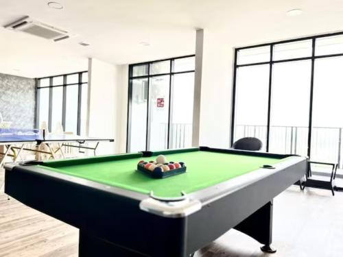 a pool table in a room with glass windows at Jeff & Ricky Homestay112-Studio Podium Apartment Kuching in Maong Bazaar