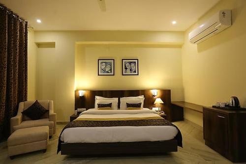 a hotel room with a bed and a chair at Regenta Central Mewargarh, Near Biological park in Udaipur