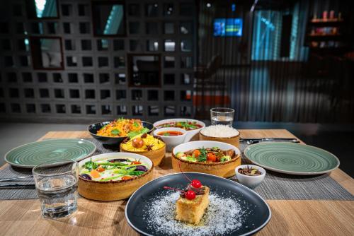 a table with plates of food and bowls of food at AUHotel -Zayed International Airport-Located in Transit Area -Onwards Boarding Pass Required in Abu Dhabi
