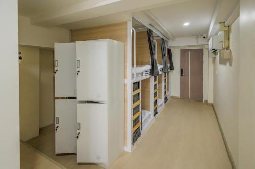 a hallway with white refrigerators in a room at Reezq Hostel in Ban Khlong Bang Sai