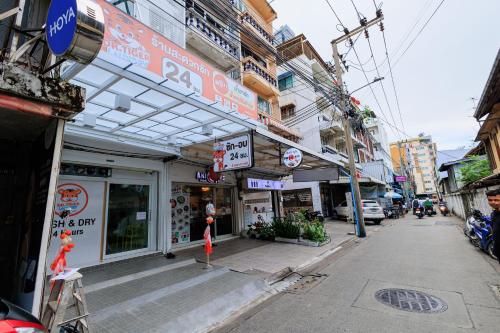 a street with a building with signs on it at Reezq Hostel in Ban Khlong Bang Sai