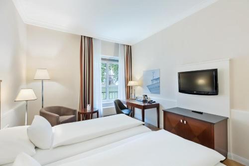 a hotel room with two beds and a flat screen tv at Austria Trend Parkhotel Schönbrunn Wien in Vienna