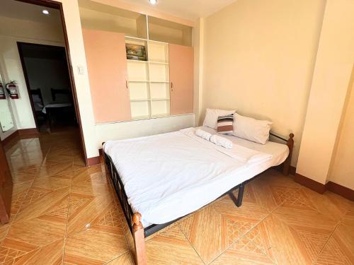a small bed in a room with a window at Manora Apartment in Talisay