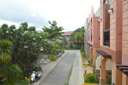 an empty alley between buildings with a scooter parked on the side at Manora Apartment in Talisay