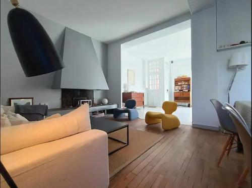 un salon avec un ours en peluche jaune assis sur le sol dans l'établissement Ancienne Poste du village, à Étables