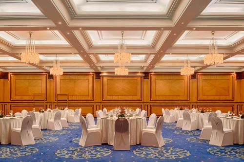 a banquet hall with white tables and chairs and chandeliers at Sheraton Tunis Hotel in Tunis