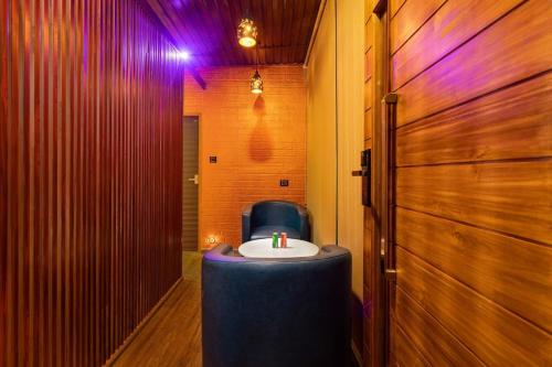 a bathroom with a sink and a blue chair at Eterno Camellia & Elettaria Resort with Pool in Munnar
