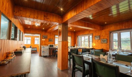 a restaurant with wooden walls and tables and chairs at Poshtel, Meghma , Sandakphu in Darjeeling