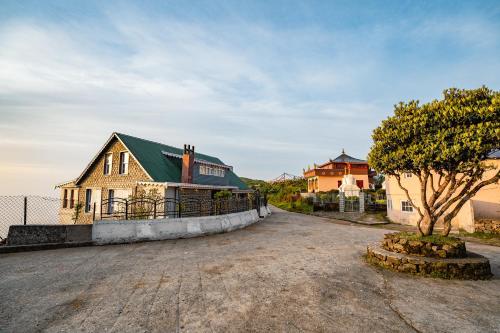 a house with a green roof and a tree at Poshtel, Meghma , Sandakphu in Darjeeling