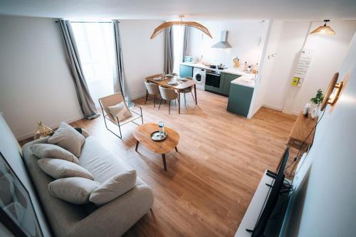 a living room with a couch and a table at Le Berry Soft - Spacieux & Chaleureux - Proche Gare in Châteauroux
