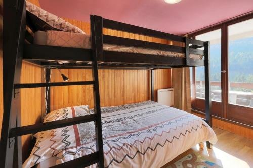 deux lits superposés dans une chambre avec fenêtre dans l'établissement Le Carbet des Oursons - Appt à Bresse vue montagne, à La Bresse